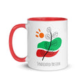 White ceramic 11 oz coffee mug with red rim and inside featuring black botanical line art over green and red abstract shapes, with an orange sun and Syndicated Passion lettering below.