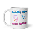 White glossy 11 oz ceramic mug with bold blue and pink typography reading 'Guided by Angels Moved by Music' alongside colorful swirling musical notes and blue angel illustrations — a joyful spiritual music gift by Syndicated Passion.