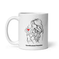 White ceramic 11 oz coffee mug featuring black line art of a woman holding a steaming cup with a red heart, with Syndicated Passion lettering below.