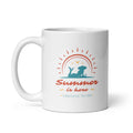 White ceramic 11 oz coffee mug featuring a teal silhouette of a girl beneath a coral sun with golden birds, “Summer is here” lettering, and Syndicated Passion branding.